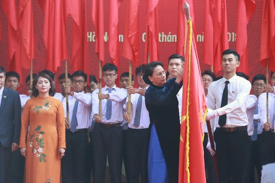 Chủ tịch Quốc hội Nguyễn Thị Kim Ngân thay mặt lãnh đạo Đảng và Nhà nước gắn Huân chương Độc lập hạng Ba lên lá cờ của nhà trường