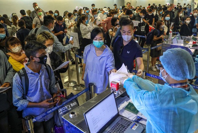 Nhiều hành khách đến sân bay Tân Sơn Nhất đã đeo khẩu trang. Ảnh: Hữu Khoa.