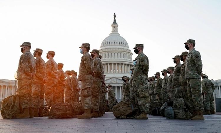 Một nhóm binh sĩ Vệ binh Quốc gia tập hợp bên ngoài tòa nhà quốc hội ở Washington DC, Mỹ, trước khi Hạ viện họp bỏ phiếu xem xét bãi nhiệm Tổng thống Donald Trump. Ảnh: Reuters.
