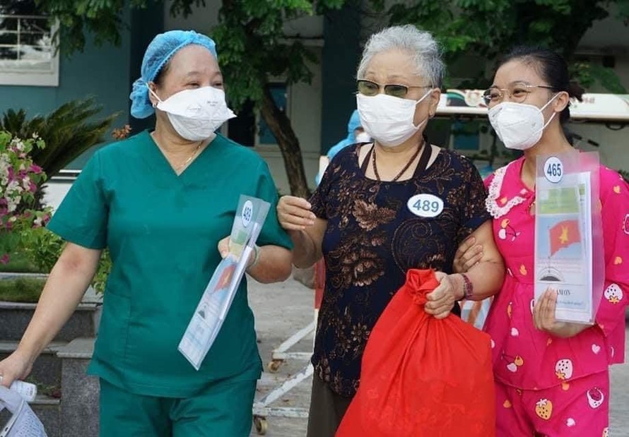 Điều dưỡng Đặng Thị Công (áo xanh) chia sẻ niềm vui với các bệnh nhân COVID-19 được công bố khỏi bệnh tại Đà Nẵng tháng 8/2020 (Ảnh: Lê Bảo)