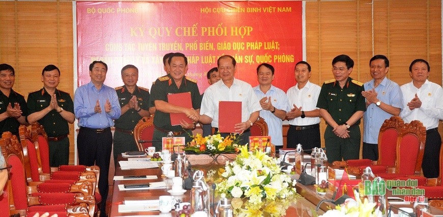 Thượng tướng Võ Minh Lương và Thượng tướng Bế Xuân Trường trao Quy chế phối hợp giữa Bộ Quốc phòng và Hội CCB Việt Nam. Ảnh: qdnd.vn