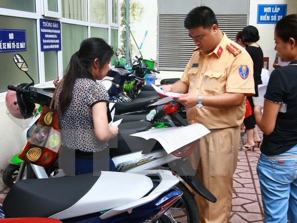 Công an quận Hai Bà Trưng, Hà Nội làm thủ tục đăng ký đăng ký xe môtô điện, xe máy điện cho nhân dân trước ngày 1/7/2016. (Ảnh: Doãn Tấn/TTXVN)
