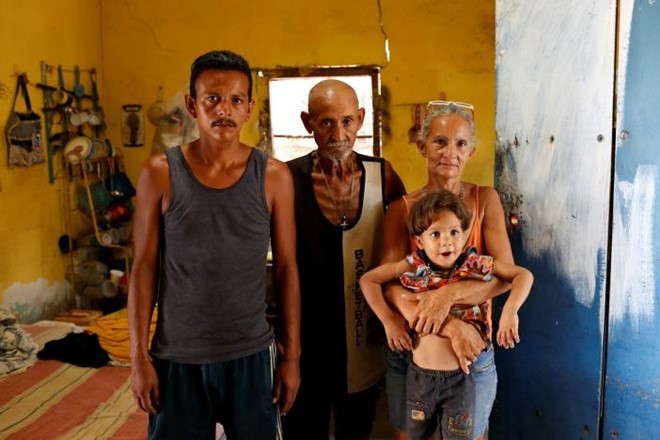 Zulay Pulgar (phải), 43 tuổi, bế cậu con trai Emmanuel khi chụp ảnh chân dung cùng chồng Maikel Cuauro (trái), 30 tuổi và cha Juan Pulgar, 73 tuổi. Ảnh: Reuters.