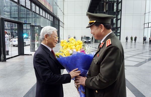 Tổng Bí thư Nguyễn Phú Trọng đón nhận bó hoa tươi thắm từ Bộ trưởng Tô Lâm.