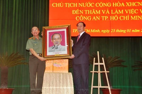 Chủ tịch nước Trần Đại Quang tặng ảnh Bác Hồ cho Công an TPHCM. Ảnh Việt Văn