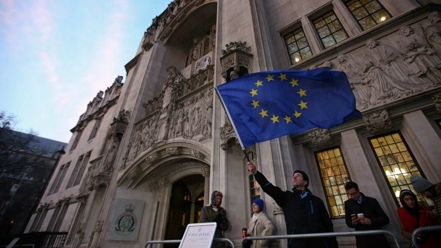 Một người đàn ông phất cờ EU trong lúc xếp hàng chờ vào Tòa án Tối cao tại London ngày 24/1.