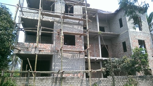 Gia đình ông Nguyễn Cao Được, người có tên trong danh sách hộ nghèo, đang hoàn thiện ngôi nhà ba tầng. 