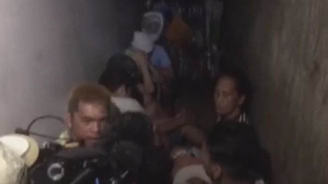 Phương tiện truyền thông quay lại cảnh các tù nhân được phát hiện trong nhà giam sau kệ sách ở đồn cảnh sát tại Manila.