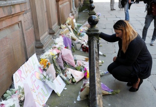 Một phụ nữ đặt hoa tưởng nhớ nạn nhân vụ tấn công ở nhà thi đấu Manchester, trung tâm thành phố. Ảnh: Reuters