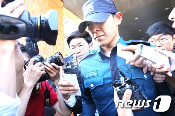 Hình ảnh T.O.P rời trụ sở cảnh sát hôm 5/6. Ảnh: News1.