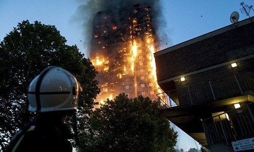  Lính cứu hỏa đứng phía dưới quan sát đám cháy tại tòa chung cư Grenfell, London. Ảnh: LNP
