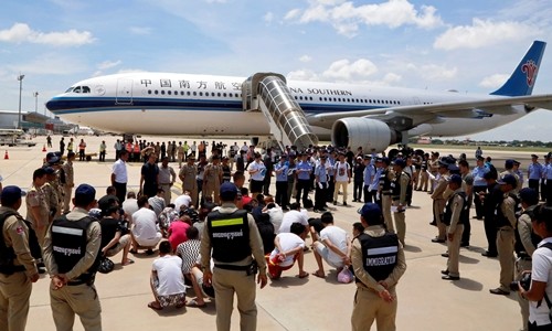 Các nghi phạm Trung Quốc lừa đảo, tống tiền qua điện thoại chuẩn bị được đưa lên máy bay về nước tại sân bay Phnom Penh, Campuchia, ngày 6/7. Ảnh: Reuters.