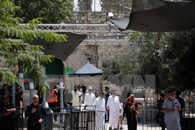 Các tín đồ Hồi giáo đi qua máy dò kim loại tại khu vực lối vào đền thờ Al-Aqsa ở Jerusalem ngày 23/7. (Nguồn: AFP/TTXVN)