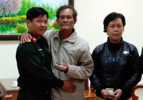  Thượng úy Lê Đăng Linh (trái) trả lại tài sản cho người đánh rơi. Ảnh: Khánh Hương.