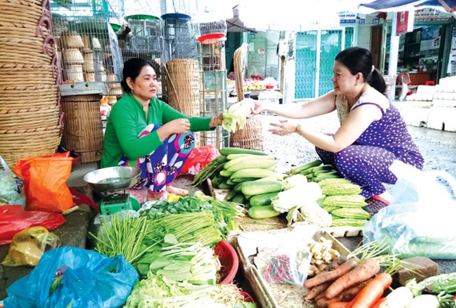 Bà Sơn Xà Pha đang bán rau cải ở chợ Hòa Bình (Hòa Bình, Bạc Liêu). Ảnh: Hòa Hội.