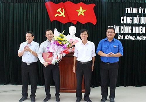 Đại diện Ban thường vụ Thành ủy Đà Nẵng trao quyết định, tặng hoa cho ông Nguyễn Bá Cảnh (thứ hai từ trái qua). Ảnh: Dangbodanang