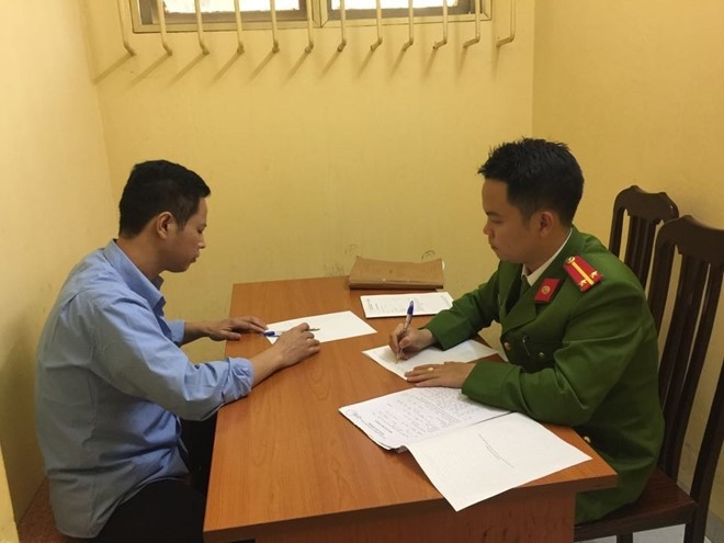 Cán bộ Công an quận Đống Đa lấy lời khai Nguyễn Duy Linh. 