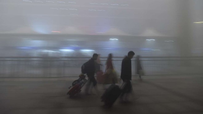 Hành khách di chuyển trong tình trạng sương mù dày đặc ở Trung Quốc. Ảnh: SCMP. 