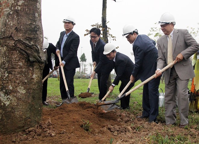 Chủ tịch UBND Hà Nội Nguyễn Đức Chung cùng các đại biểu tham gia trồng cây xoài tại nút giao cầu Nhật Tân. 
