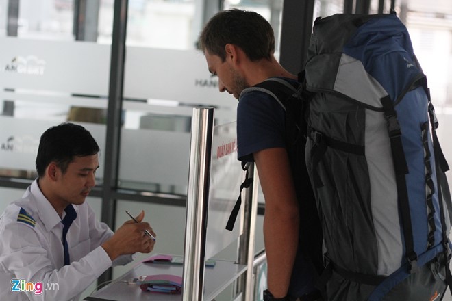 Một vị khách nước ngoài lấy vé buýt nhanh tại bến Kim Mã. 