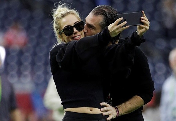 Lady Gaga chụp ảnh tình tứ cùng bạn trai Christian Carino trên sân khấu sự kiện Super Bowl vào cuối tuần trước. Ảnh: ET Online w