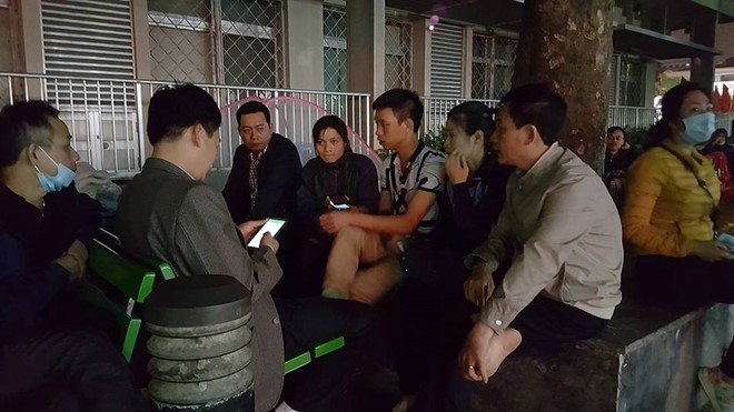 Người nhà bệnh nhân (người mặc áo cộc tay ngồi giữa) trình bày sự việc với phóng viên tại Bệnh viện Bạch Mai tối ngày 6/3.