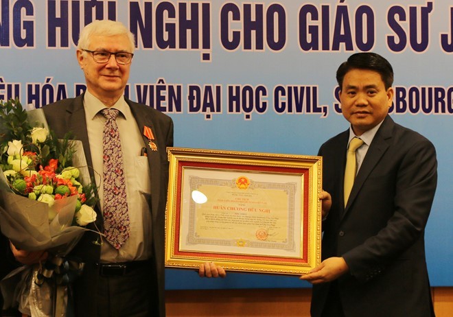 Ông Nguyễn Đức Chung trao Huân chương Hữu nghị cho giáo sư Joel Leroy. 
