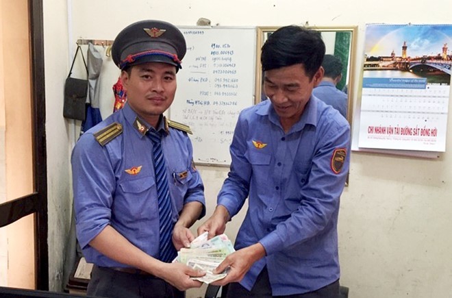 Trưởng tàu TN2 Quang Cương bàn giao tiền bỏ quên trên toa cho hành khách. 