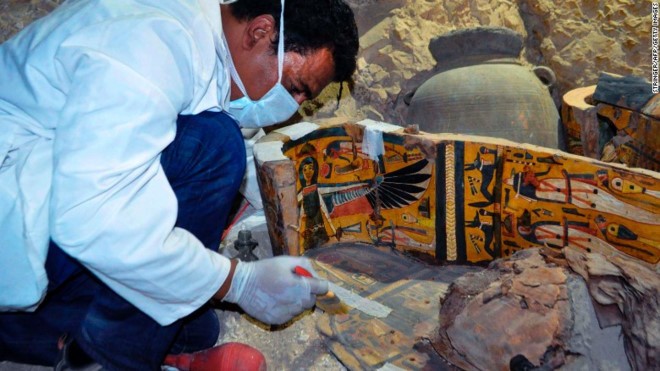 Thành viên của đoàn khảo cổ Ai Cập xem xét quan tài bằng gỗ hôm 18/4. Ảnh: Getty. 
