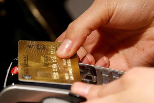 Khách hàng sử dụng thẻ tín dụng không tiếp xúc tại Paris. Ảnh: Reuters