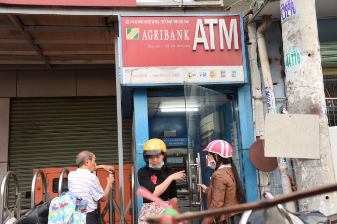 Một số ngân hàng đã đưa ra quy định dừng giao dịch tại các cây ATM vào ban đêm nhằm đề phòng tội phạm thẻ sau khi xảy ra một số vụ chủ thẻ mất tiền trong tài khoản lúc nửa đêm. Trong ảnh: người dân rút tiền tại trụ ATM Agribank trên đường Nơ Trang Long, Q