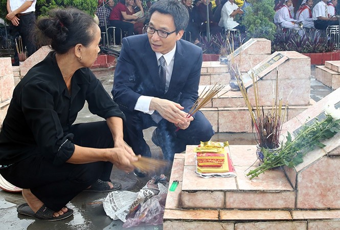Phó Thủ tướng Vũ Đức Đam trò chuyện với thân nhân liệt sĩ tại Nghĩa trang liệt sĩ xã Nam Tân, huyện Nam Sách, tỉnh Hải Dương. Ảnh: VGP