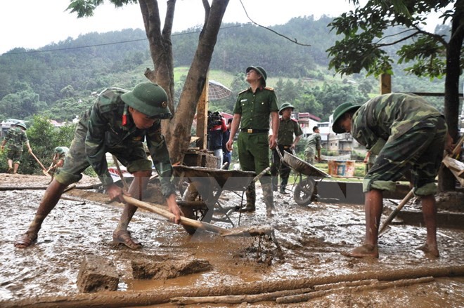 Các chiến sỹ tham gia dọn dẹp bùn đất tại trường học ở Mù Cang Chải. 