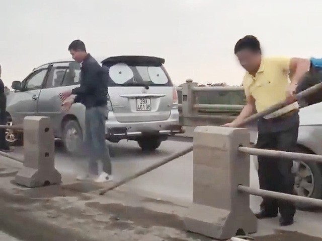 Các tài xế cố tình tháo dải phân cách để chuyển làn trên cầu Thanh Trì. Ảnh: Dân trí