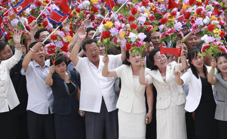 Đoàn người cầm cờ và hoa chào đón hai nhà lãnh đạo tại thủ đô Bình Nhưỡng. Ảnh: SCMP
