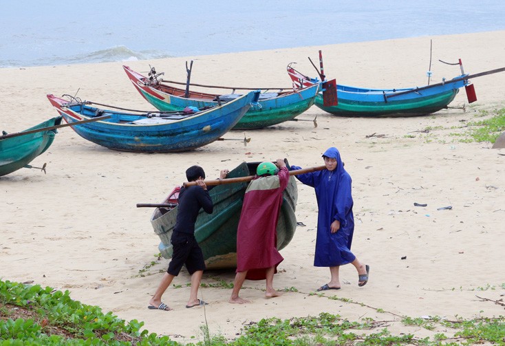 Ngư dân Quảng Bình vận chuyển thuyền lên bờ tránh bão. Ảnh: Báo Quảng Bình