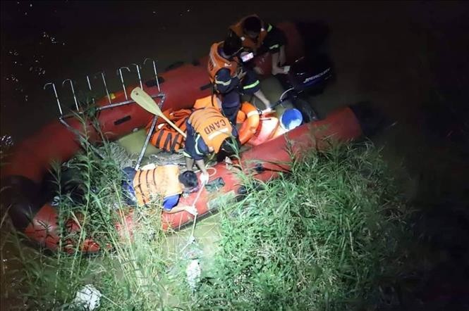 Lực lượng cứu hộ tìm thấy nạn nhân bị rơi xuống sông Hồng. Ảnh: TTXVN