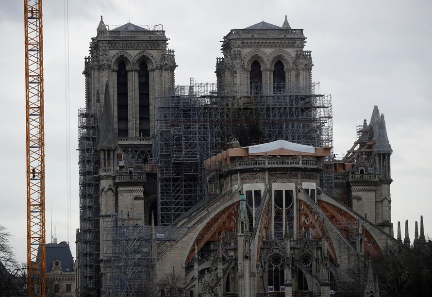 Các kỹ sư đang triển khai một cần cẩu tới để tháo dỡ phần giàn giáo trước Nhà thờ Đức bà vốn bị hư hỏng sau vụ hỏa hoạn hồi đầu năm 2019. Ảnh: Reuters