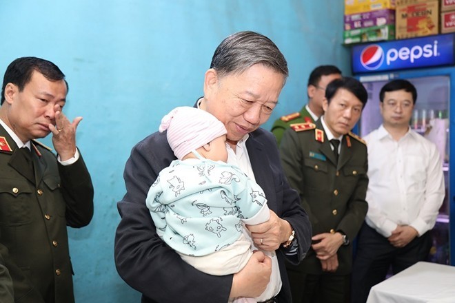 Bộ trưởng Công an Tô Lâm thăm gia đình chiến sỹ công an hy sinh tại Đồng Tâm. Ảnh: CAND