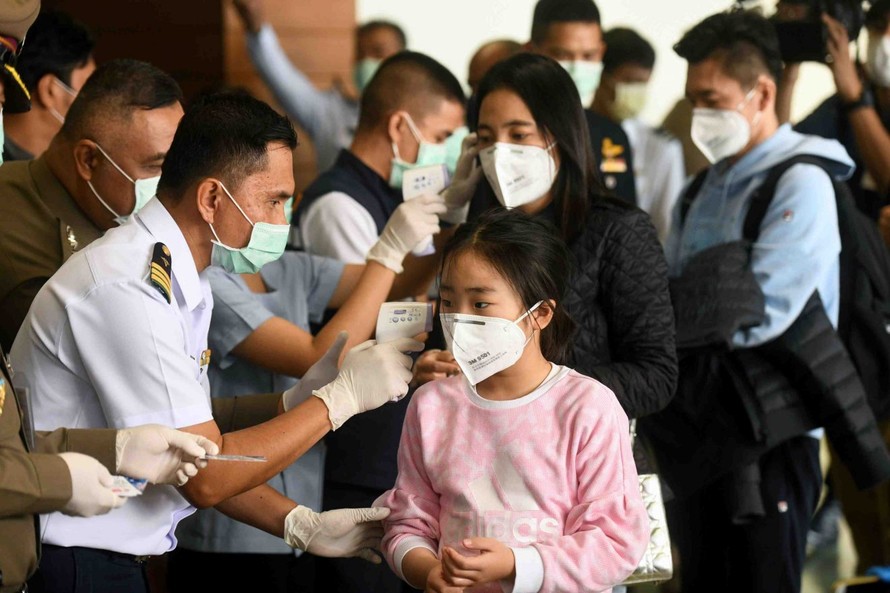 Một nhân viên y tế sử dụng nhiệt kế hồng ngoại để kiểm tra nhiệt độ của một khách du lịch đến sân bay Don Mueang của Bangkok, Thái Lan. Ảnh: Reuters