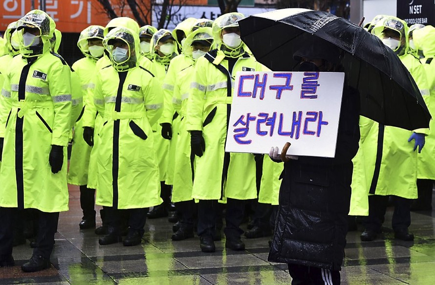 Một người dân Daegu cầm tấm biển với nội dung: "Hãy cứu lấy Daegu". Ảnh: AP