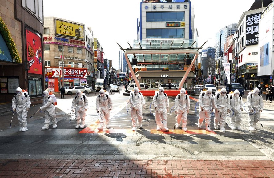 Binh sĩ Hàn Quốc xịt thuốc khử trùng trên đường phố Daegu. Ảnh: AP