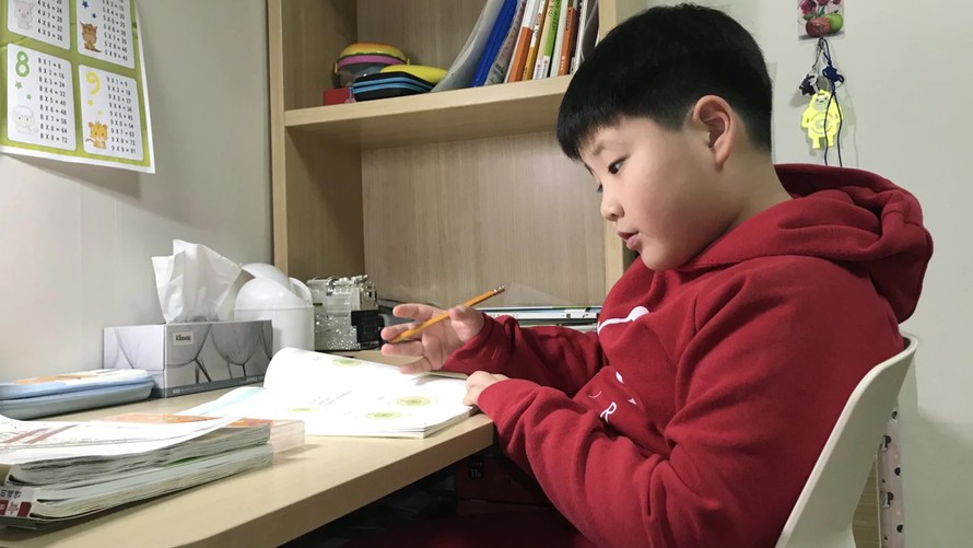 Yoo Ju-chan, 8 tuổi, dành thời gian để học và chơi với chó vào kỳ nghỉ "đặc biệt". Ảnh: The Washington Post