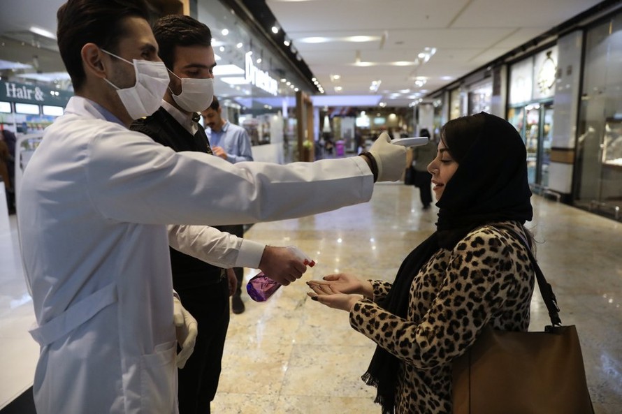 Một phụ nữ được đo thân nhiệt trong trung tâm thương mại ở thủ đô Tehran, Iran. Ảnh: AP