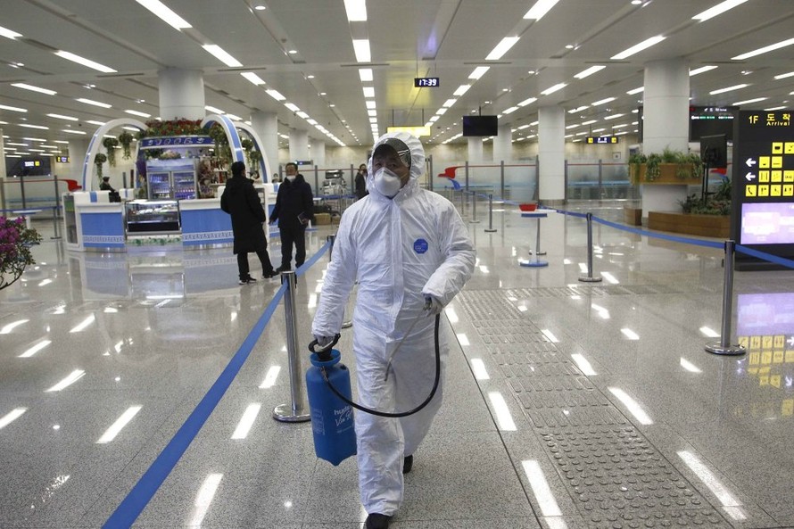 Một nhân viên y tế xịt thuốc khử trùng tại sân bay Bình Nhưỡng. Ảnh: AP