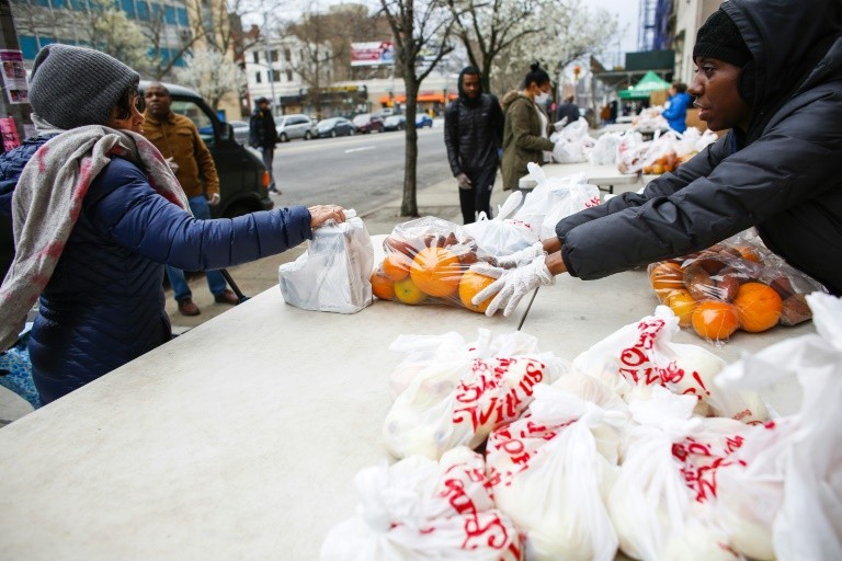 Người dân khu Harlem, New York nhận đồ cứu trợ của tổ chức City Harvest. Ảnh: AFP