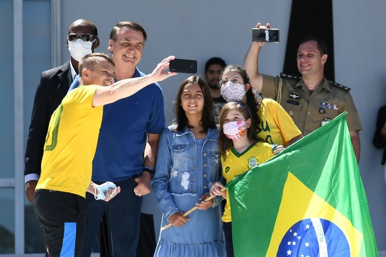 Tổng thống Bolsonaro không ngần ngại chụp ảnh tự sướng cùng người biểu tình. Ảnh: AFP
