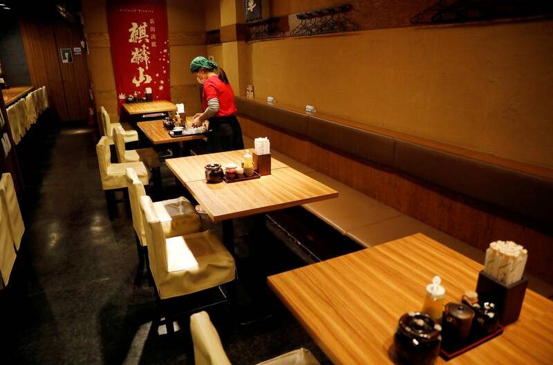 Một nữ nhân viên đang dọn bàn tại một nhà hàng ở Tokyo vào ngày 8/5. Ảnh: Reuters