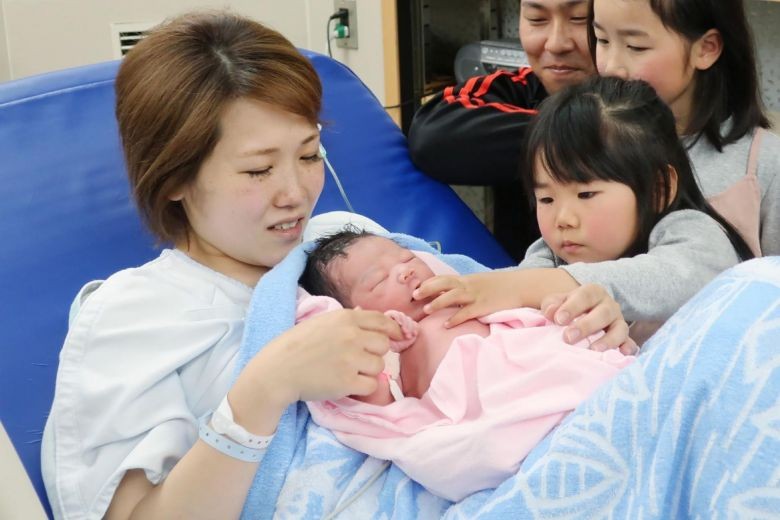 Một người phụ nữ đang bế đứa trẻ mới chào đời của mình tại một bệnh viện thuộc thành phố Izumi, tỉnh Osaka. Ảnh: AFP