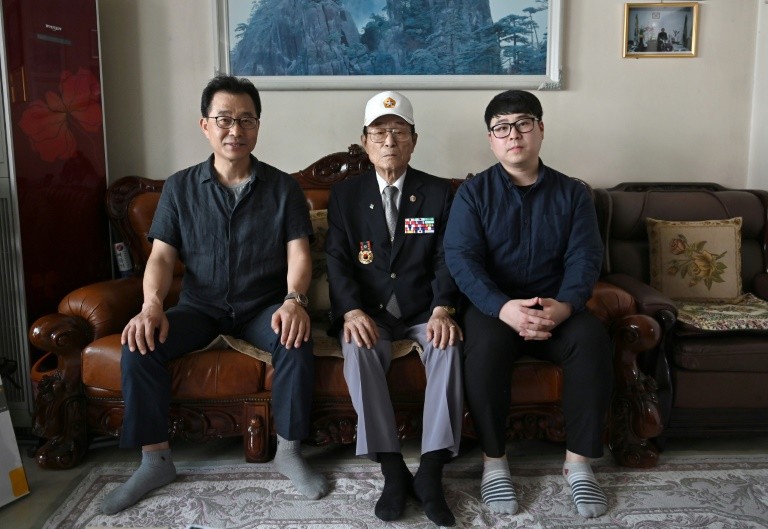 Yang Tae-sung (giữa) cùng con trai Yang Kyung-mo (trái) và cháu trai Yang Hee-kon (phải) tại nhà riêng ở Seoul. Ảnh: AFP